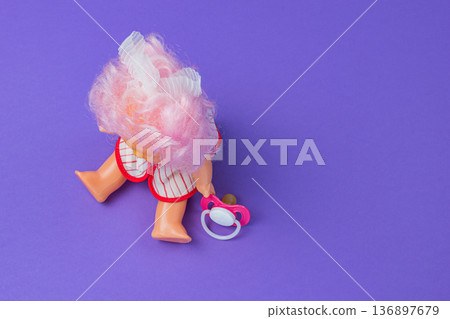 A child's toy. A doll on a colored background. Toy store concept A child's toy. A doll on a colored background. Toy store concept 136897679