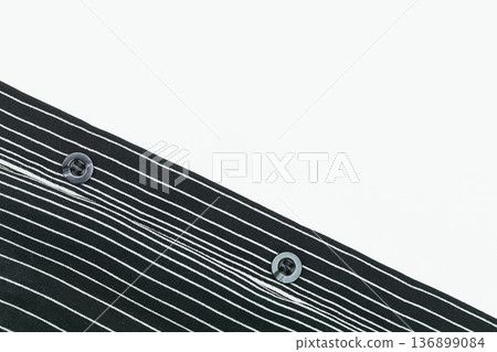 Two buttons on part of a black white linear down shirt 136899084