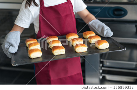 Girl baking cookies in the kitchen using the oven Girl baking cookies in the kitchen using the oven 136899332