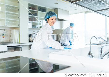 穿著衛生白大褂的男女工作人員清潔廚房 136899343