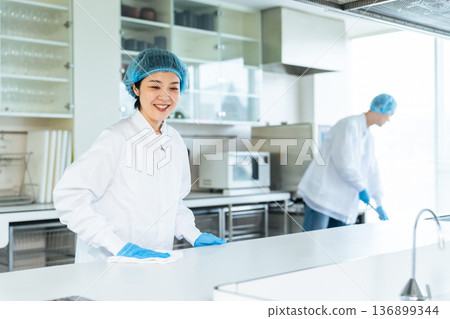 穿著衛生白大褂的男女工作人員清潔廚房 136899344