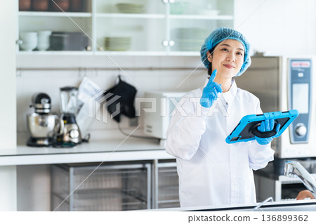 Male and female workers in sanitary white coats checking the kitchen 136899362