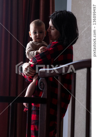Mother Holding Baby in Dimly Lit Room Mother Holding Baby in Dimly Lit Room 136899497