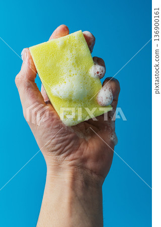 Dish detergent. Washing sponge in a person's hand Dish detergent. Washing sponge in a person's hand 136900161
