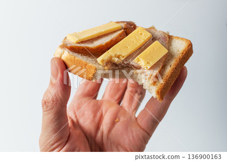 Sandwich in hand. The concept of malnutrition or unhealthy eating habits 136900163