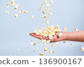 Falling cornflakes on the arm of a young simple girl 136900167