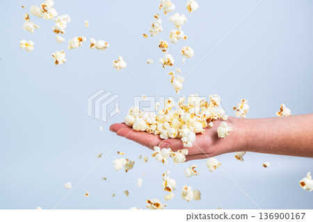 Falling cornflakes on the arm of a young simple girl 136900167