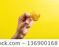 Potato chips in hand on yellow background 136900168