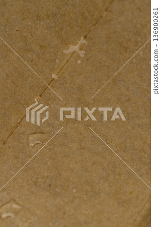 wet hard yellow cardboard for packaging goods and products, part of the corrugated cardboard packaging is covered with water 136900261
