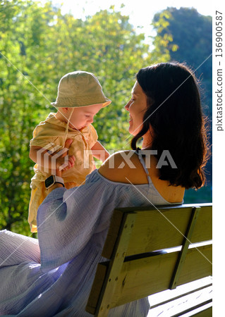 Mother and baby enjoying a sunny day in the park Mother and baby enjoying a sunny day in the park 136900587