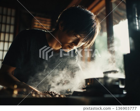 一位年輕人在一棟古老的日本房屋裡烘焙咖啡豆。 一位年輕人在一棟古老的日本房屋裡烘焙咖啡豆。 136903777