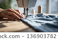 Woman's hands operating a sewing machine 136903782