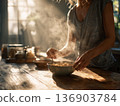 Photo of a woman mixing hot cereal in the morning light 136903784