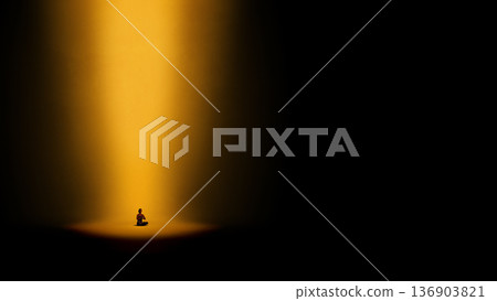 Dramatic artwork. Person meditating under golden spotlight in darkness. Dramatic artwork. Person meditating under golden spotlight in darkness. 136903821