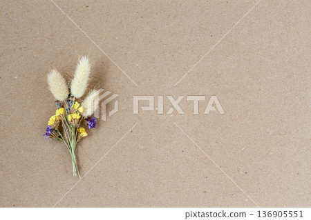 Dried flower bouquet with bunny tail grass placed on brown craft paper background, copy space for design. Natural background for greeting card, wedding invitation, packaging mockup, floral backdrop Dried flower bouquet with bunny tail grass placed on brown craft paper background, copy space for design. Natural background for greeting card, wedding invitation, packaging mockup, floral backdrop 136905551