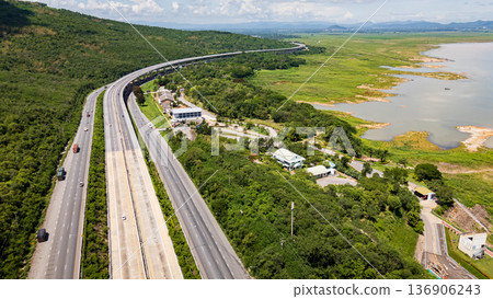 Drone shot The M6 motorway Nakhon Ratchasima Province - Bang Pa-in Lam Ta Khong River and Mountain. Motorway Korat Thailand Drone shot The M6 motorway Nakhon Ratchasima Province - Bang Pa-in Lam Ta Khong River and Mountain. Motorway Korat Thailand 136906243