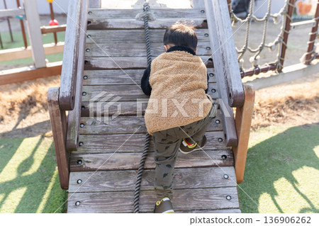 child playing on playground equipment in the park child playing on playground equipment in the park 136906262