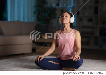 Asian woman doing guided breathing exercises in the night Asian woman doing guided breathing exercises in the night 136906967