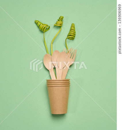 Paper cups and wooden forks and spoon, long green decorative branches, 136906969