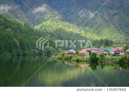 Mountains and villages reflected in the Tadami River 136907668