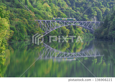 The Tadami Line runs through the Tadami River Bridge, covered in fresh greenery The Tadami Line runs through the Tadami River Bridge, covered in fresh greenery 136908221