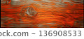 Textured wooden plank, showcasing the wood's grain and knots in vibrant orange tones. 136908533