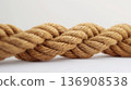 Thick jute rope tied in a knot, with a focus on the texture against a white background. 136908538
