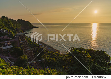 黃昏時的日本海,以及駛過尾梅川車站的當地列車。 黃昏時的日本海,以及駛過尾梅川車站的當地列車。 136908870