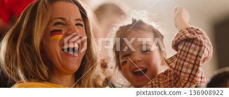 Excited football fans, supporting German national team in live soccer match at stadium. Excited football fans, supporting German national team in live soccer match at stadium. 136908922