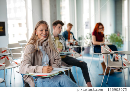 Group of college students attending lecture in university hall. 136908975
