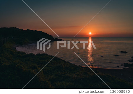 夕陽染紅的沙灘與人們的剪影 136908980