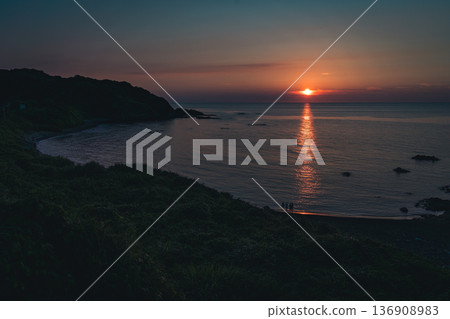 夕陽染紅的沙灘與人們的剪影 136908983