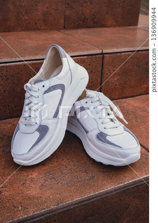 Fresh white leather sneakers without brand marks displayed. For design templates online shops and sustainability-themed marketing. Clean blank sneakers Fresh white leather sneakers without brand marks displayed. For design templates online shops and sustainability-themed marketing. Clean blank sneakers 136909944