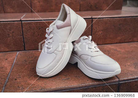 Fresh beige leather sneakers without brand marks displayed. For design templates online shops and sustainability-themed marketing. Clean blank sneakers Fresh beige leather sneakers without brand marks displayed. For design templates online shops and sustainability-themed marketing. Clean blank sneakers 136909968