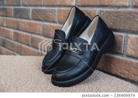 Elegant black leather womens shoes displayed. New black leather female shoes with glossy finish, perfect for style magazines footwear ads and modern elegant fashion e-commerce layouts. No logo 136909979