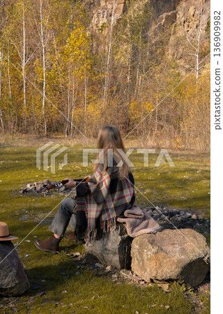 Beautiful blonde girl playing acoustic guitar and singing relaxing enjoying outdoors on sunny autumn day. Hippie woman in boho style learning and practicing playing musical instrument. Fall leaves Beautiful blonde girl playing acoustic guitar and singing relaxing enjoying outdoors on sunny autumn day. Hippie woman in boho style learning and practicing playing musical instrument. Fall leaves 136909982