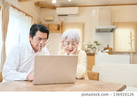 一對亞洲老年夫婦看著電腦感到困惑 136910126