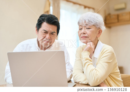 Asian senior couple confused by looking at a computer 136910128
