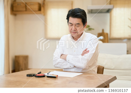 Senior Asian man thinking about the contents of his will Senior Asian man thinking about the contents of his will 136910137