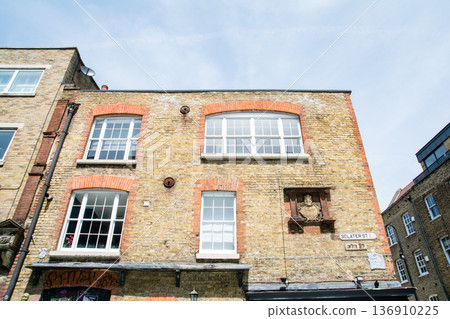 A street lined with historic brick buildings under bright sunlight in Shoreditch, East London A street lined with historic brick buildings under bright sunlight in Shoreditch, East London 136910225