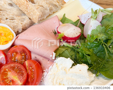 Closeup breakfast ham cheese and radish beside eggs and bread. Balanced brunch plate, protein source, natural ingredients, and wholesome nutrition concept. 136910406