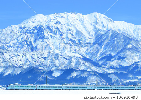 The E653 series 1000 train looks up at the snow-capped Mount Hakkai. The E653 series 1000 train looks up at the snow-capped Mount Hakkai. 136910498
