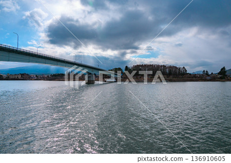 Mount Fuji and Lake Kawaguchiko Bridge hidden behind the Angel's Ladder [taken from a sightseeing boat] 136910605