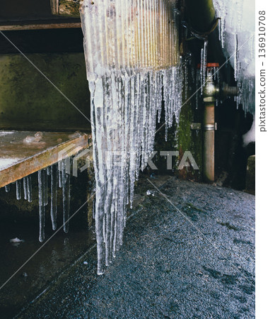 Icicles on a corrugated sheet and ice art 136910708