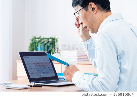 A middle-aged man checking his pension payment A middle-aged man checking his pension payment 136910864
