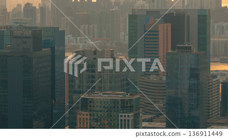 Hazy Kowloon skyline glowing under warm sunset Feb 19 2026 136911449