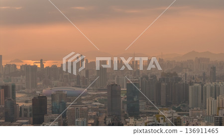 Hazy Kowloon skyline glowing under warm sunset Feb 19 2026 136911465