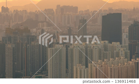 Hazy Kowloon skyline glowing under warm sunset Feb 19 2026 136911468