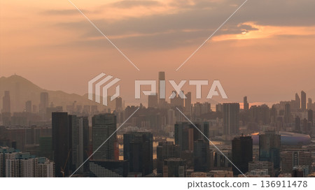 Hazy Kowloon skyline glowing under warm sunset Feb 19 2026 136911478