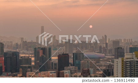 Hazy Kowloon skyline glowing under warm sunset Feb 19 2026 Hazy Kowloon skyline glowing under warm sunset Feb 19 2026 136911490